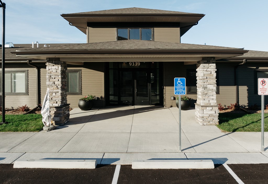 the front entrance of a building with a handicapped entrance sign