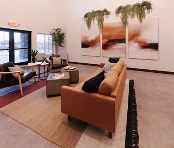 a living room with couches and chairs and art on the wall