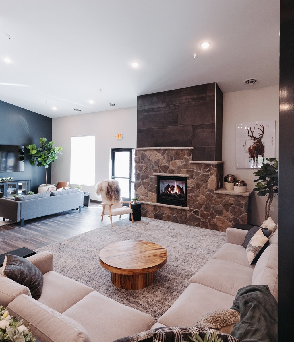 a living room with a stone fireplace and a couch and a table
