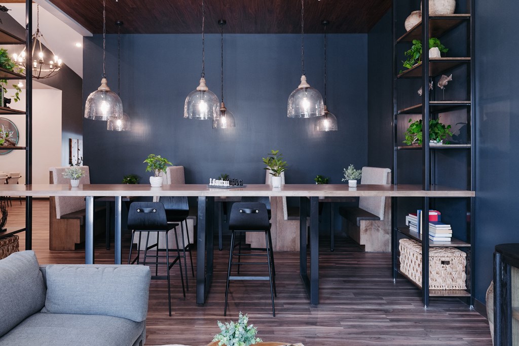a dining room with a long wooden table and chairs and a blue wall
