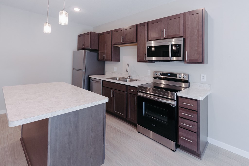 a kitchen with wooden cabinets and stainless steel appliances