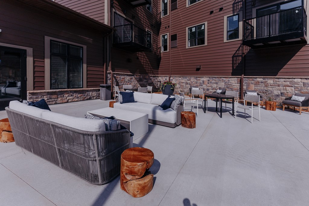 a covered patio with couches and tables on a patio