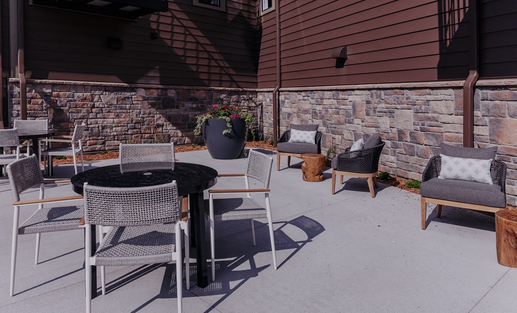 a patio with a table and chairs and a fire pit