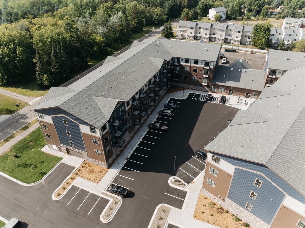 an aerial view of an apartment building with a parking lot
