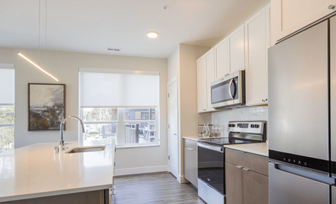 A modern kitchen with stainless steel appliances and a large window.