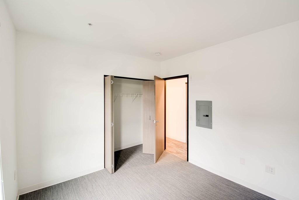 A room with a white wall and a door with a glass window.