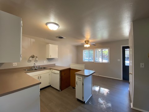 A kitchen with white cabinets and a white dishwasher.