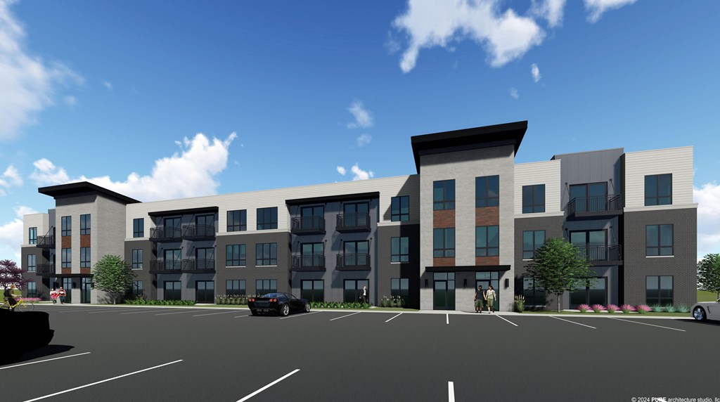 A modern apartment complex with a parking lot in front.