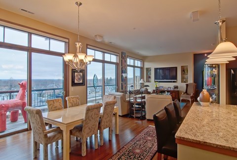 A dining room with a table and chairs and a chandelier at Cornerstone & Ravenna* Apartments, Shorewood