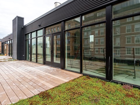 A modern building with a glass facade and a brick walkway in front.