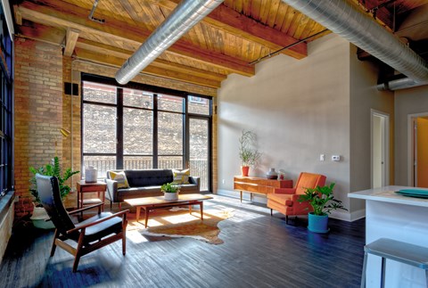 A living room with a wooden floor and a large window.