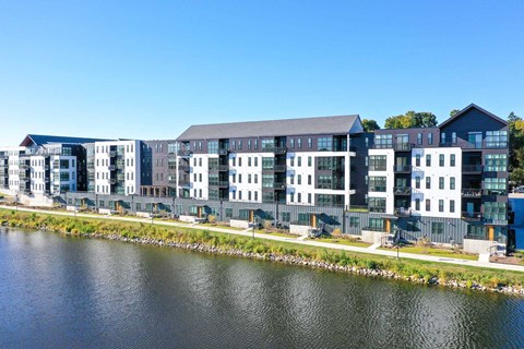 A modern building complex is situated next to a body of water.