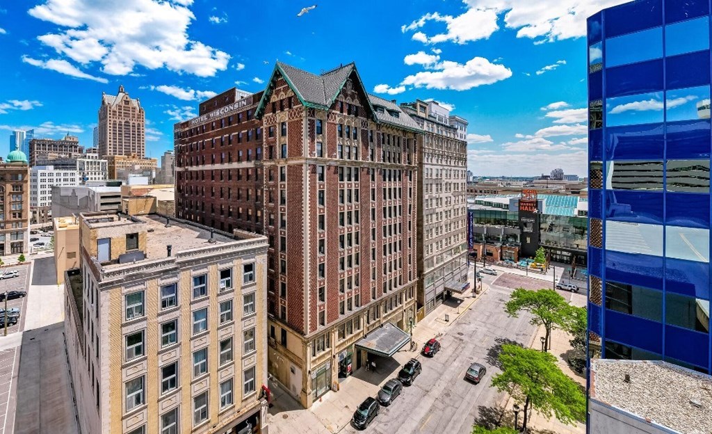 A cityscape with a large building in the foreground and a blue building on the right at Grand Wisconsin, Milwaukee