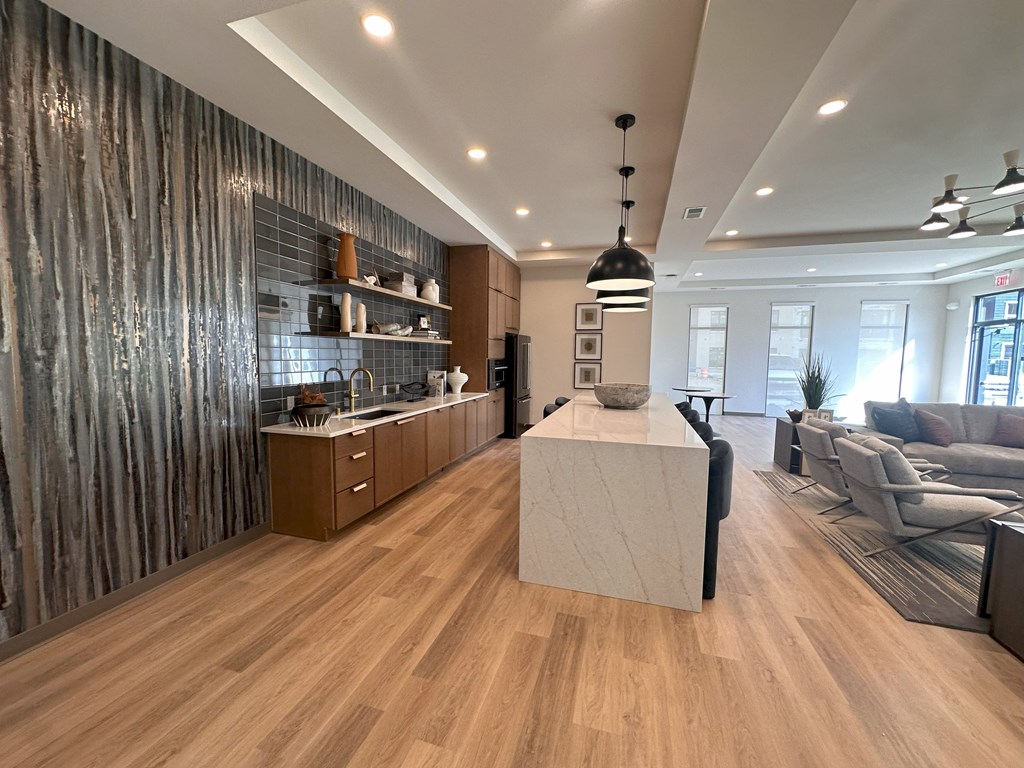 A modern kitchen with wooden floors and a central island.