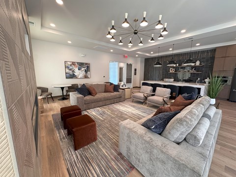 A living room with a grey couch and a brown ottoman.