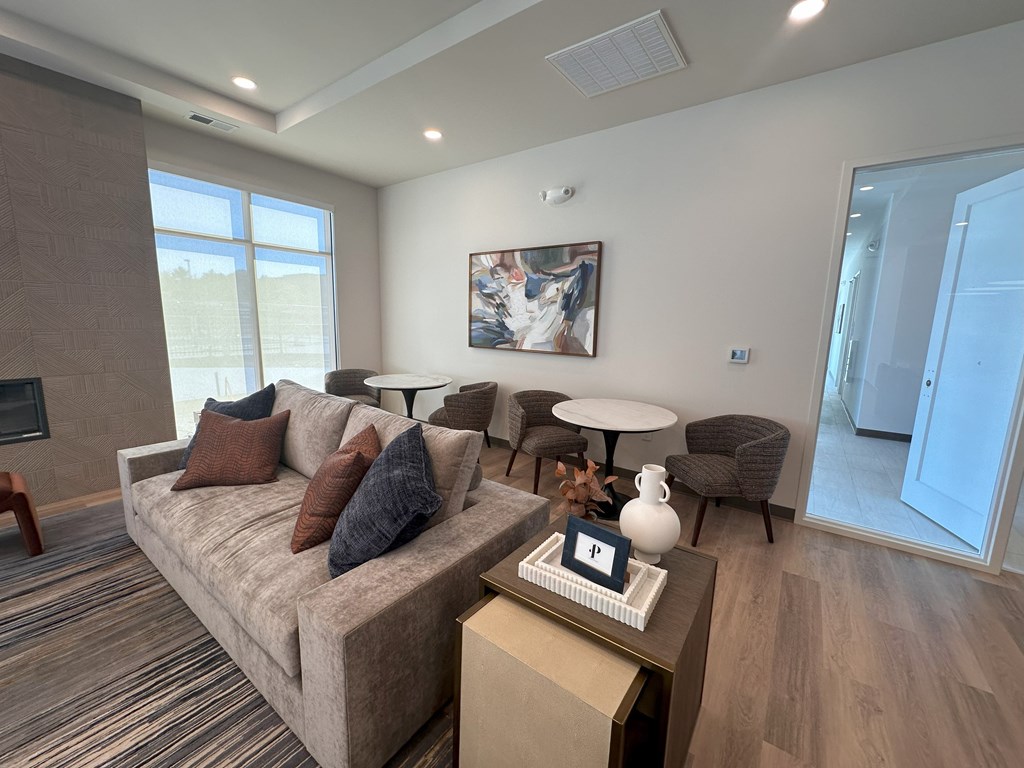 A living room with a couch, coffee table, and a painting on the wall.