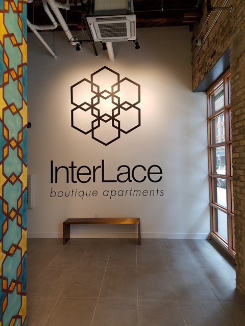 A wall with a logo that says InterLace boutique apartments.