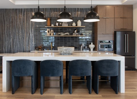 A modern kitchen with a white table and black chairs.