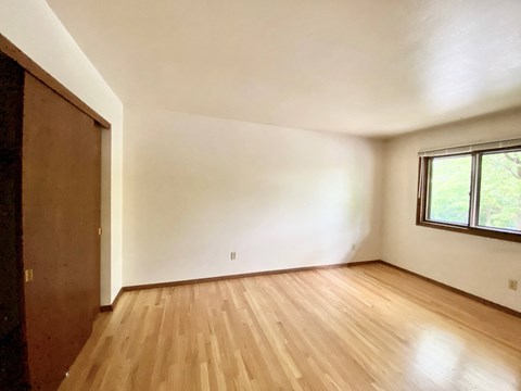 A room with wooden flooring and a window at Root River Apartments, Greendale, Wisconsin