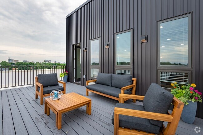 A wooden deck with two chairs and a table.