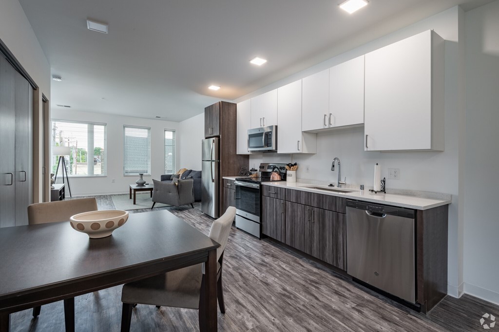 A modern kitchen with a wooden table and chairs.