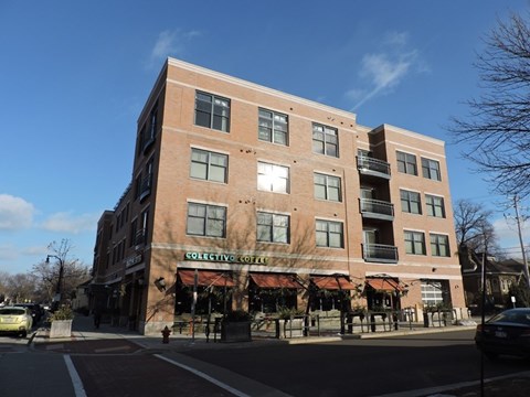 A large brick building with a coffee shop on the ground floor at Cornerstone & Ravenna* Apartments, Shorewood, WI, 53211