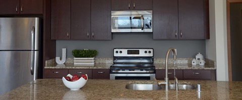 A kitchen with a stainless steel refrigerator and a stove top oven.
