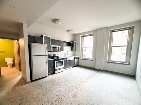 A kitchen with a refrigerator, oven, and microwave.