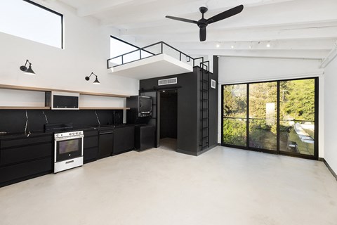 a kitchen with black cabinets and a ceiling fan
