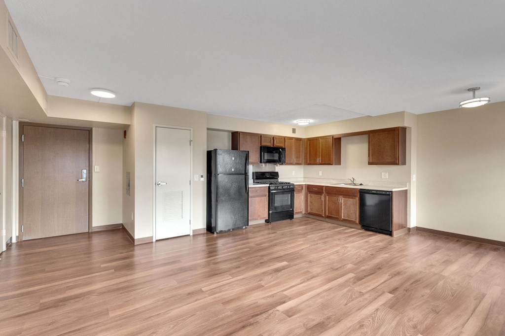 A kitchen with black appliances and wooden cabinets.
