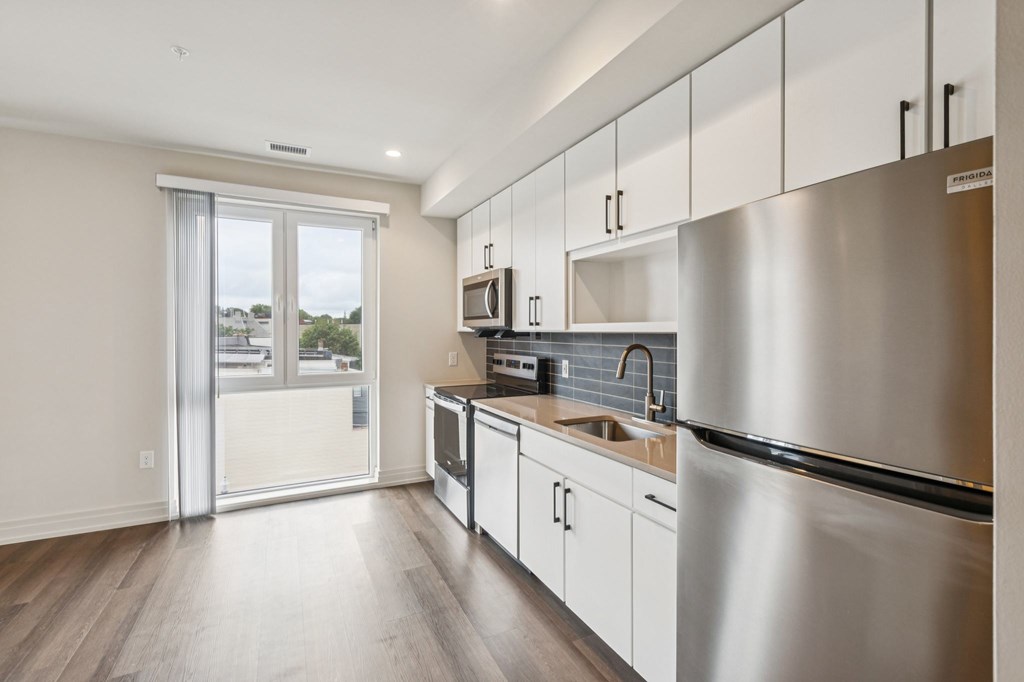 A modern kitchen with stainless steel appliances and white cabinets.