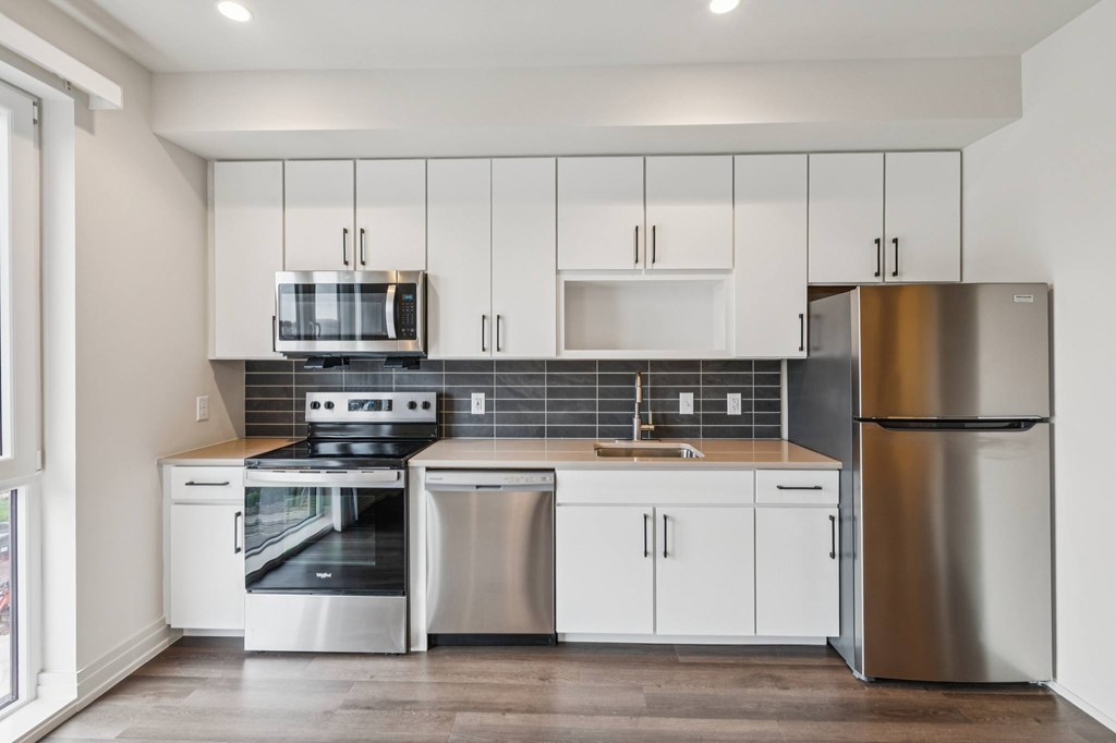 A modern kitchen with stainless steel appliances and white cabinets.