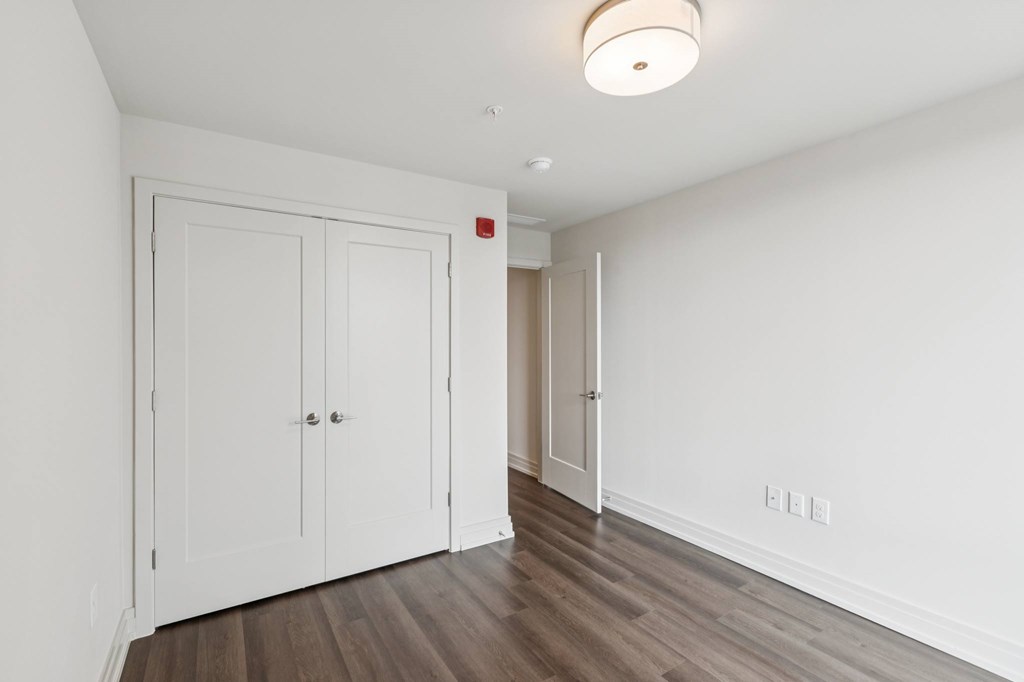 A white door with a red sign on the wall behind it.