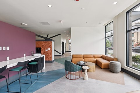 A modern office space with a pink wall and a variety of seating options.