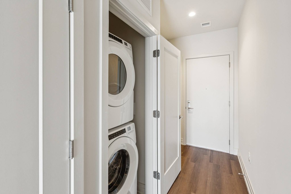 A white washing machine is in a small laundry room.