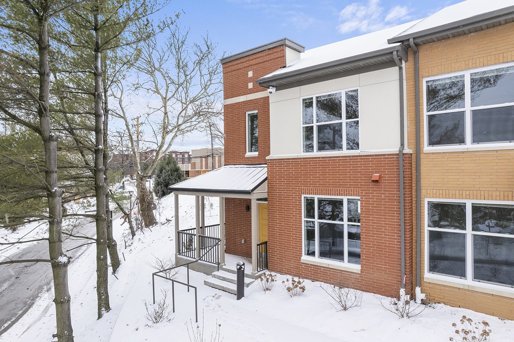 the front of a brick house in the snow