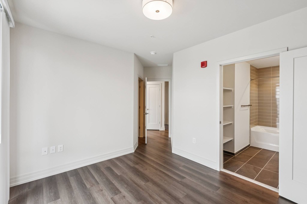 A room with a white wall and a wooden floor.