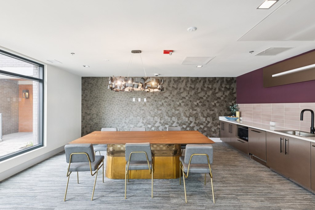 A modern dining room with a wooden table and grey chairs.