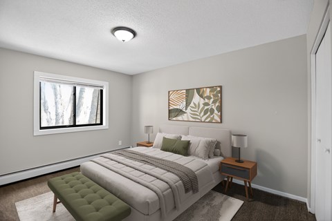A bedroom with a bed, nightstand, and window.