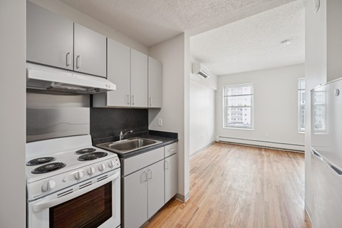 A kitchen with white appliances and wooden floors.