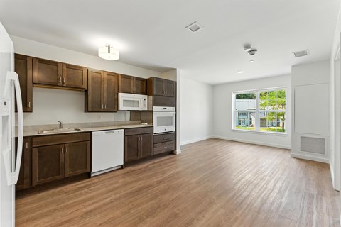 A kitchen with brown cabinets and white appliances.