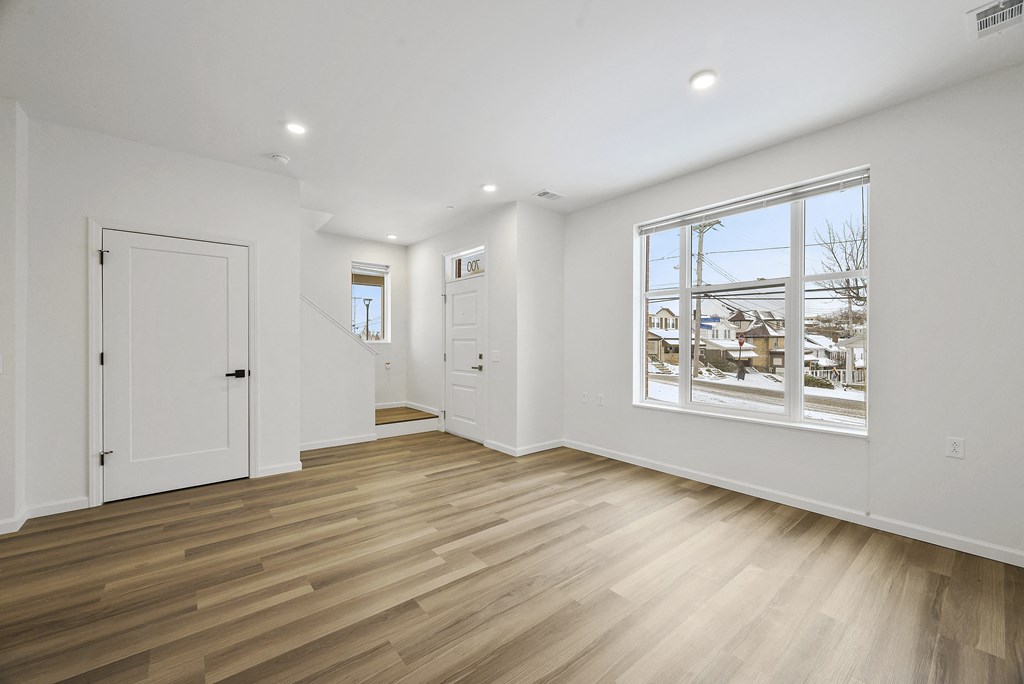 a living room with a large window and white walls