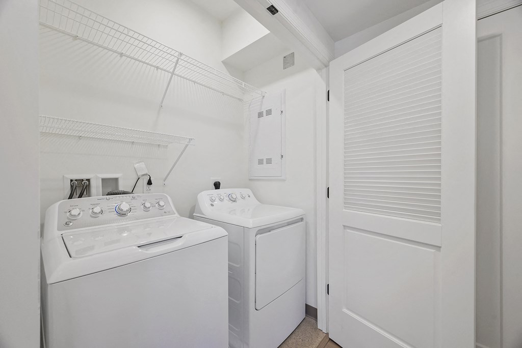 the laundry room has a washer and dryer and a door to the closet