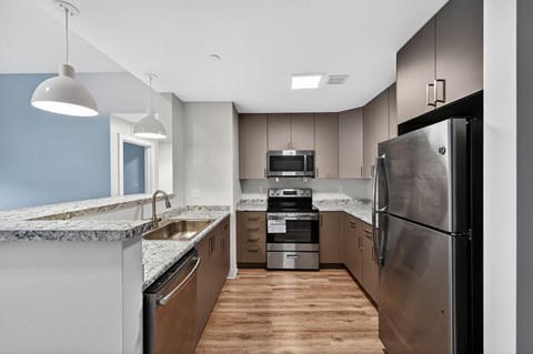 A modern kitchen with a large refrigerator and stainless steel appliances.