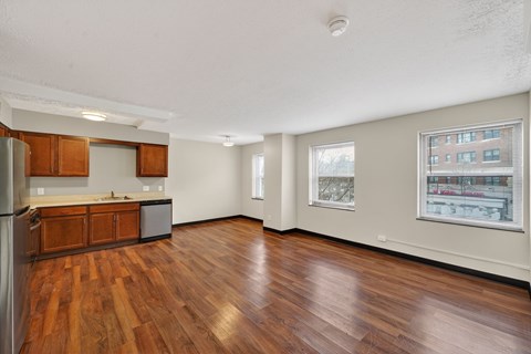 A kitchen with wooden floors and a refrigerator.