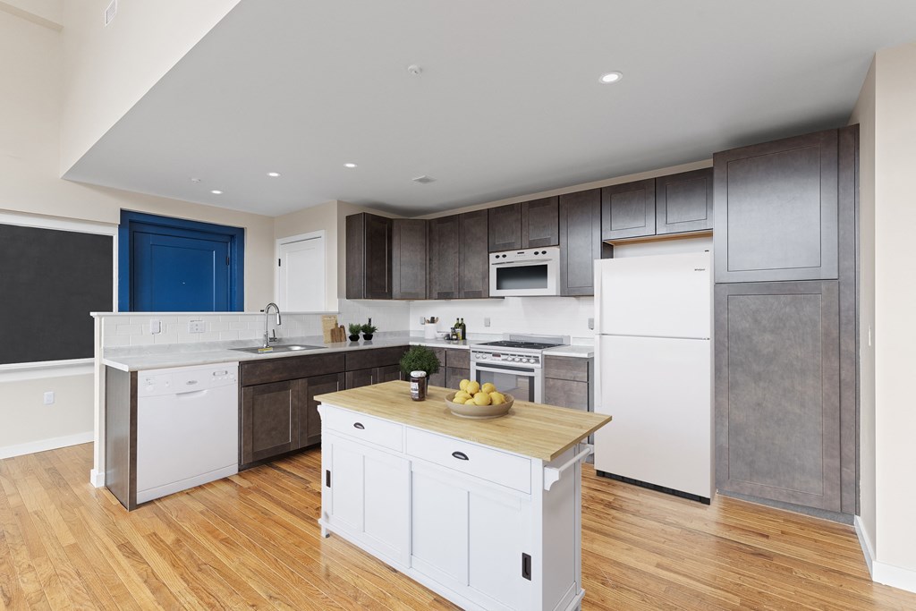 a kitchen with white cabinets and white appliances and a wooden counter top