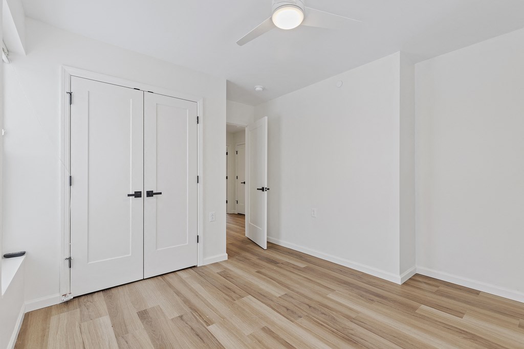 a living room with white doors and a hard wood floor