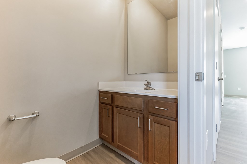 a view of the corner of a room with white walls and wooden furniture