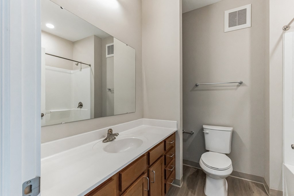 a bathroom with a large mirror and a toilet and sink