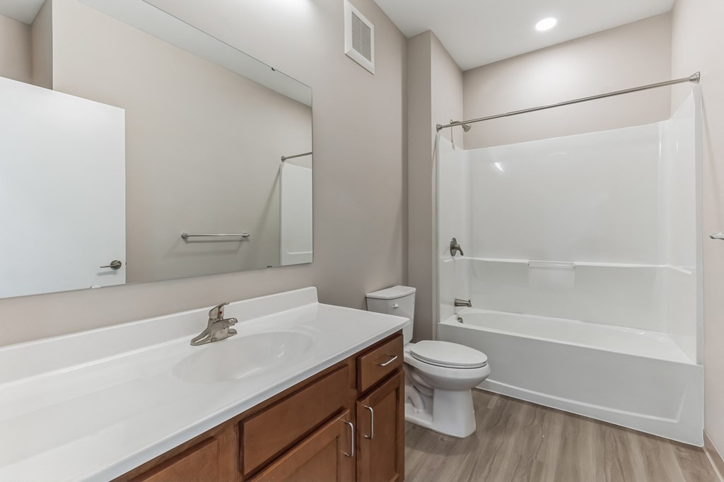 a bathroom with a large mirror and a toilet and a shower